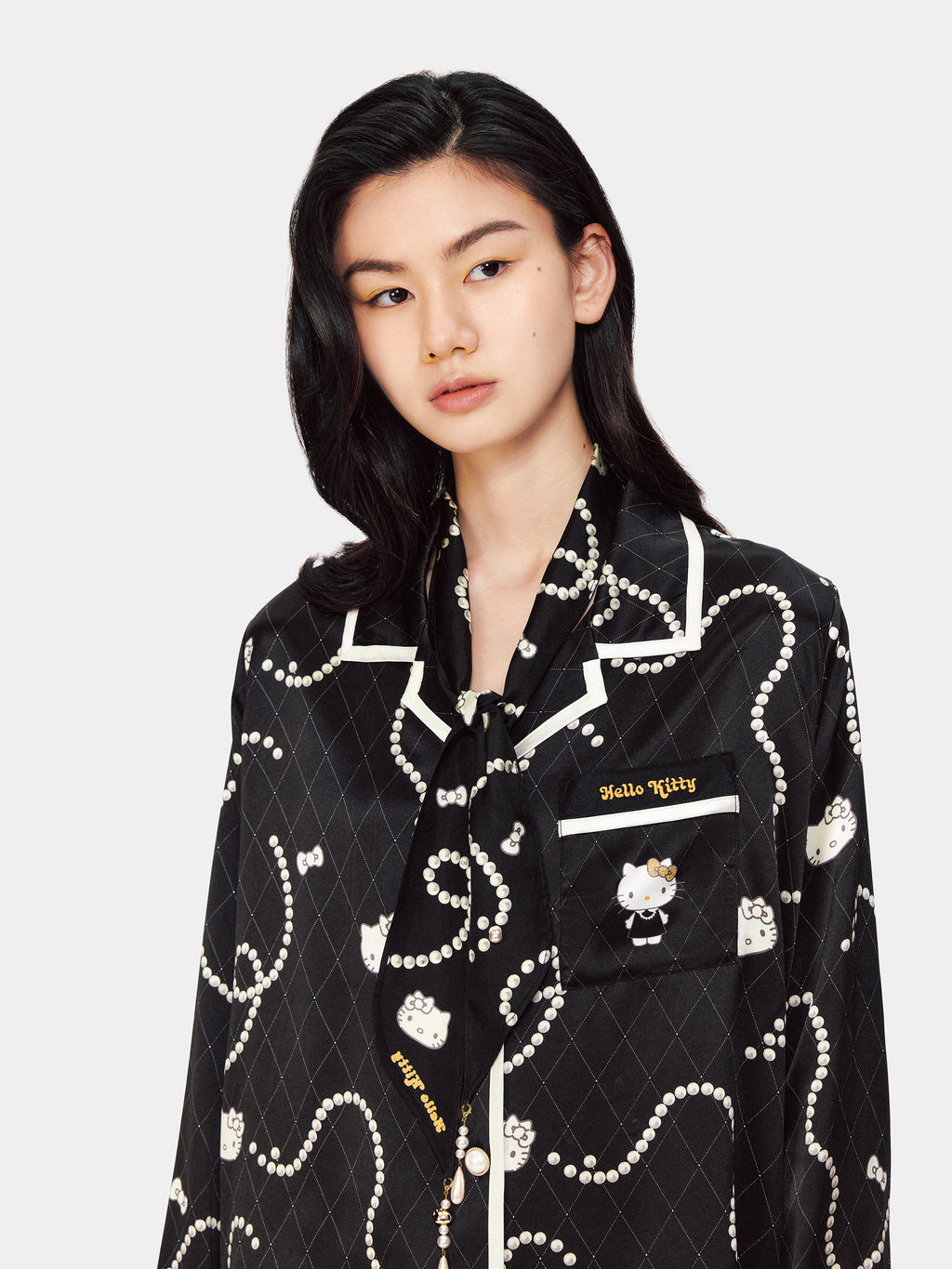 Close-up detail of the heavy mulberry silk fabric showing the Hello Kitty and pearl necklace motif print by tbh home.